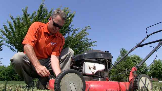 Shawn Askew, Extension Turfgrass Weed Specialist at Virginia Tech, adjust a blade on a lawn mower to help homeowners properly mow their lawns.